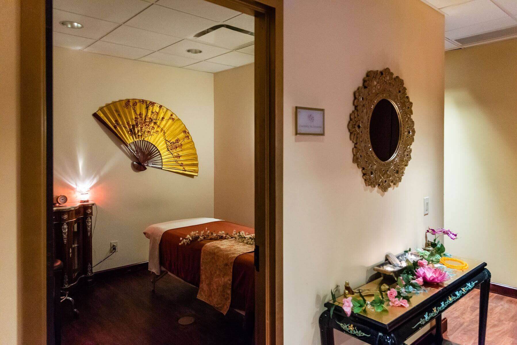 Cozy spa room with warm lighting and decorative fan on the wall.