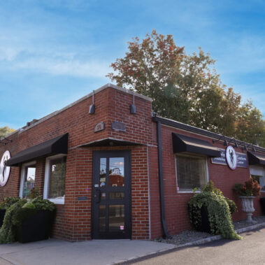 Brick building with a restaurant entrance under a clear blue sky.